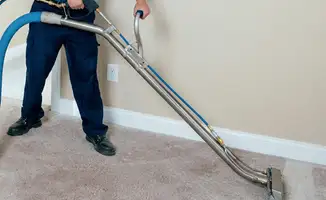 Professional operating a liquid removal machine on a carpeted floor in Duluth, MN